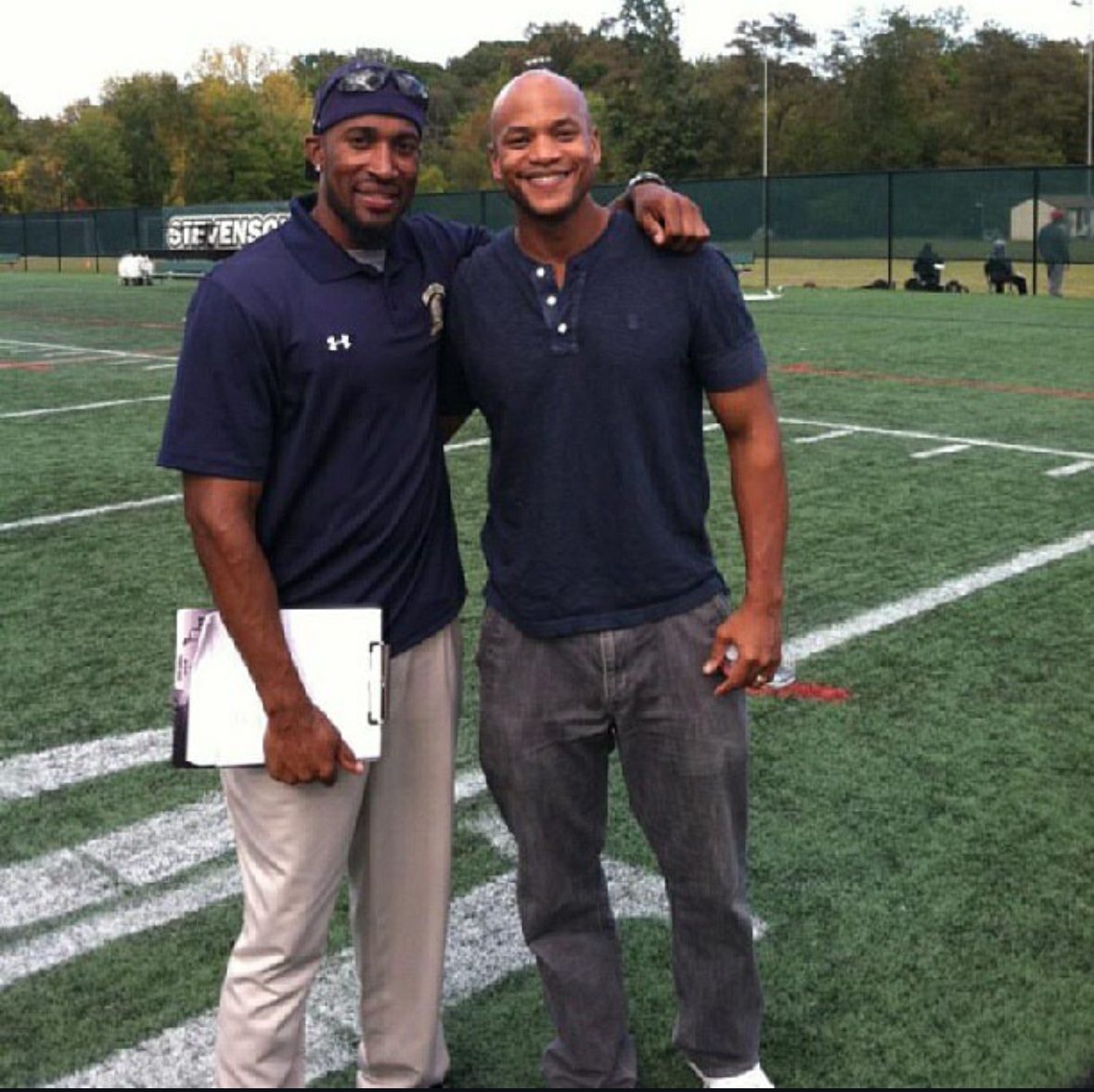 Coach Dante Coles standing on the field with another coach